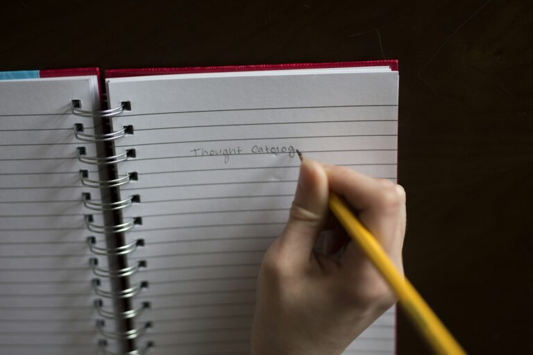 Person writing in a notebook, representing creating WordPress posts with Claude