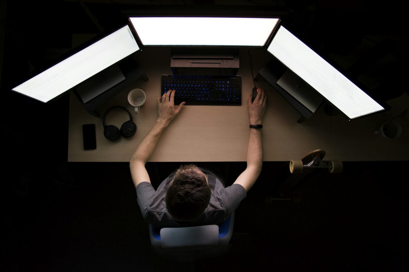Administrator facing three computer monitors, representing managing WordPress users with AI