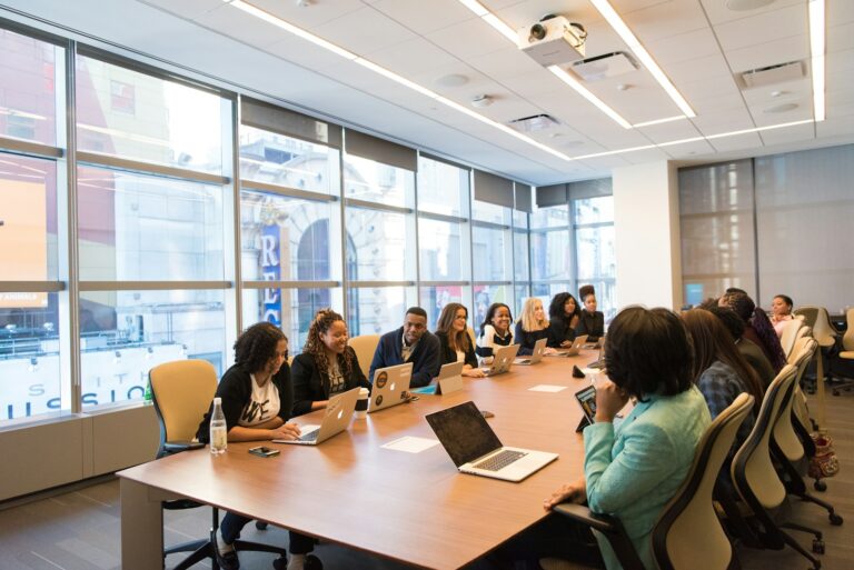 Team of software professionals working together around a table with laptops
